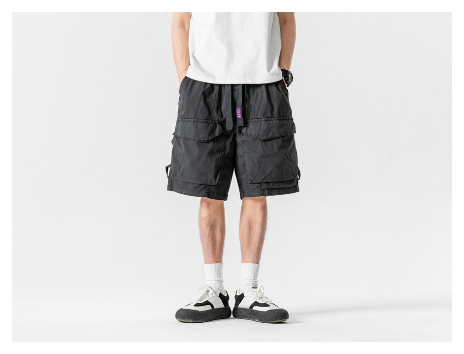 Front view of a model wearing charcoal gray cargo shorts with large flap pockets.