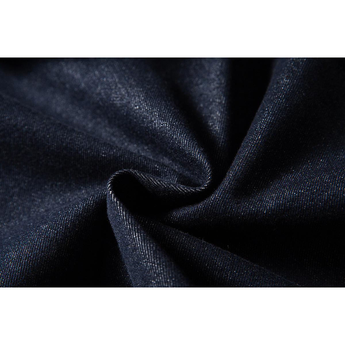 Macro view of dark indigo fabric gathered to show its woven texture.