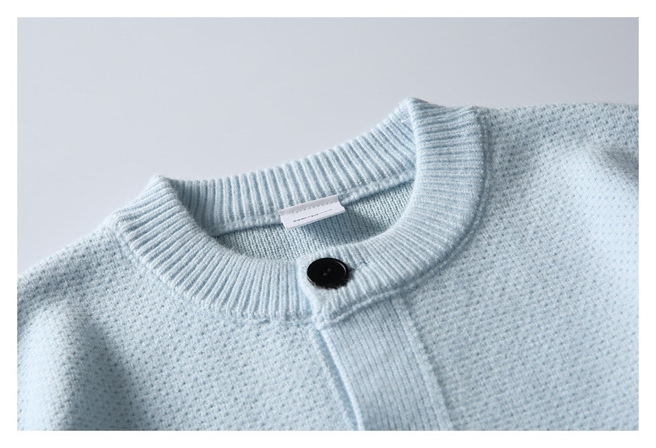 Close-up of the pale blue cardigan's ribbed neckline, top black button, and knit texture.