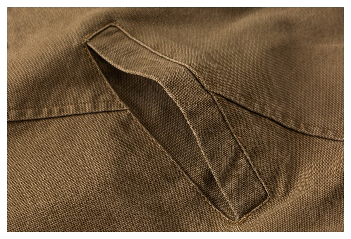 Close-up of a slanted pocket opening on brown textured jacket fabric.