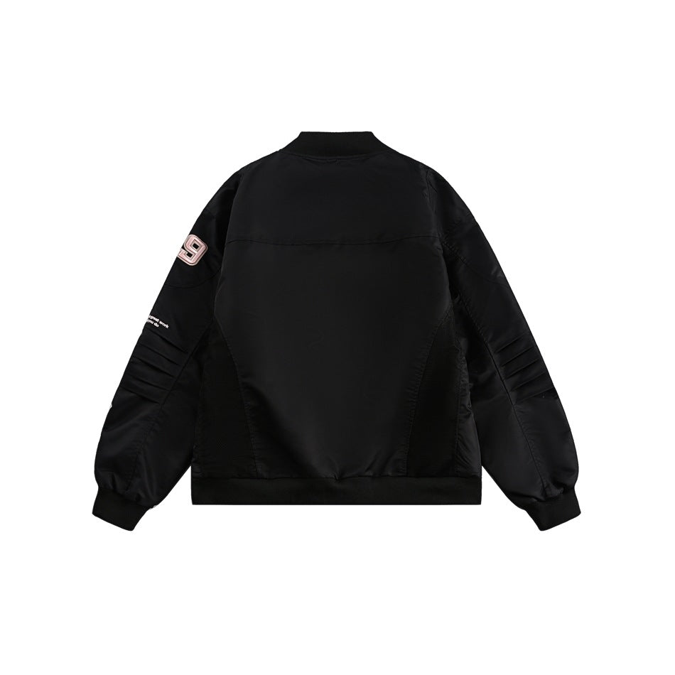 Back view of a black bomber jacket with ribbed cuffs and hem, quilted sleeve details, and a pale pink 89 patch.