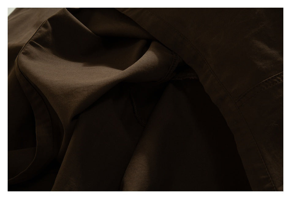 Close-up of the dark brown trousers' interior fabric and seam construction.
