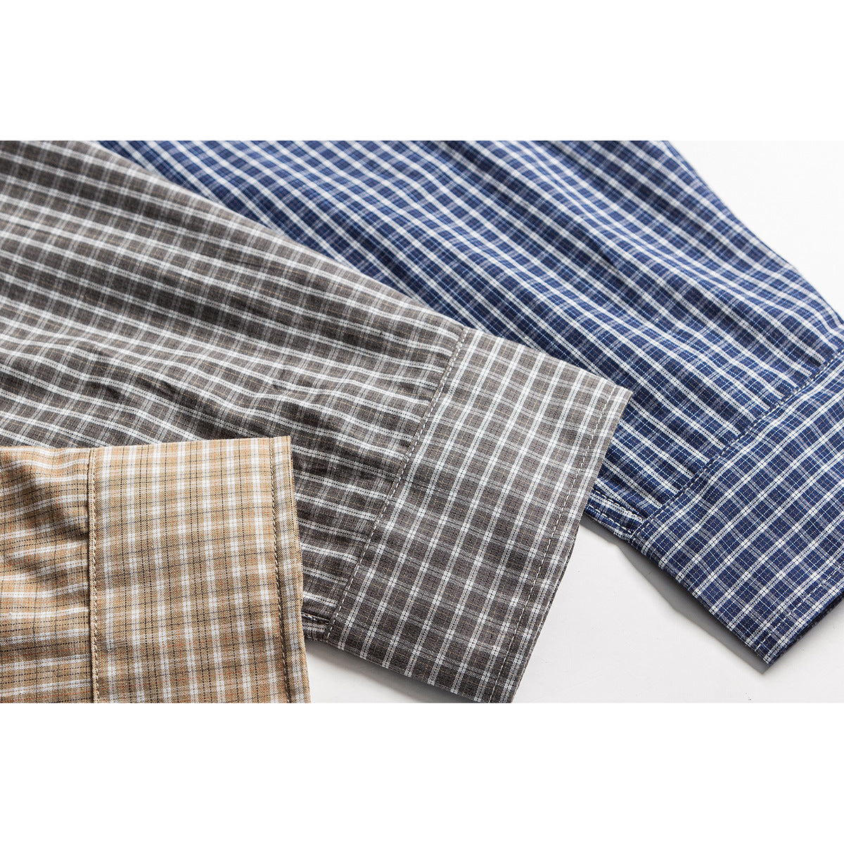 Overlapping sleeves show three plaid shirt colorways: navy, gray, and tan.