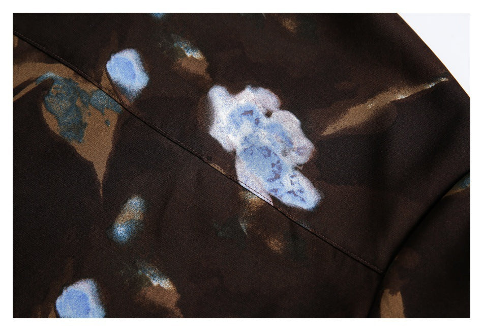 Close-up of the shirt's dark brown abstract print and diagonal stitched seam.