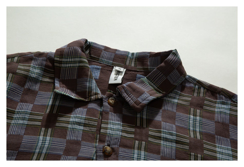 Close view of a brown patchwork-plaid button-up shirt showing its collar, buttons and sewn neck label.