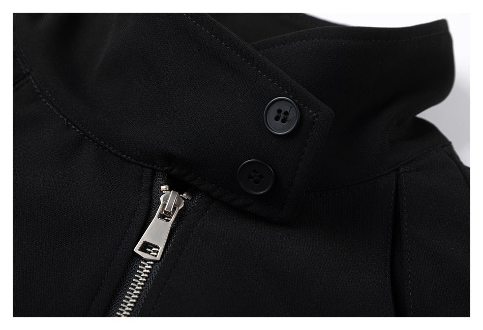 Close-up of the black jacket's high collar with two buttons and a silver zipper pull.