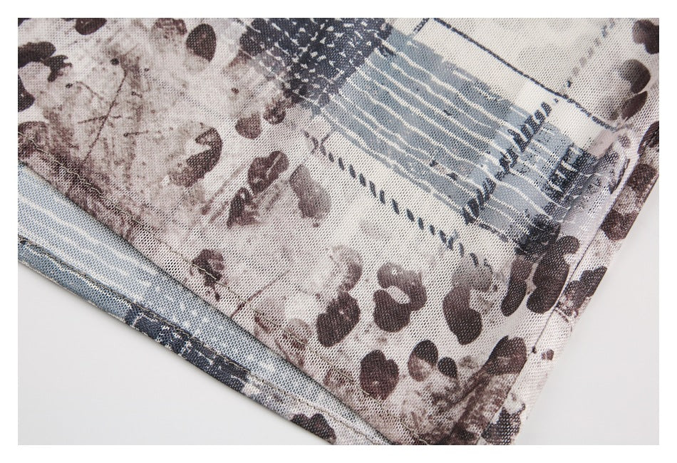 Close-up of the garment's stitched hem and abstract brown, cream, and blue-gray print.