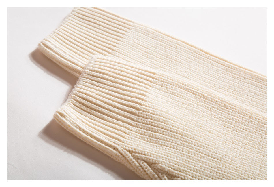 Close-up of an ivory knit sleeve ending in a broad ribbed cuff.