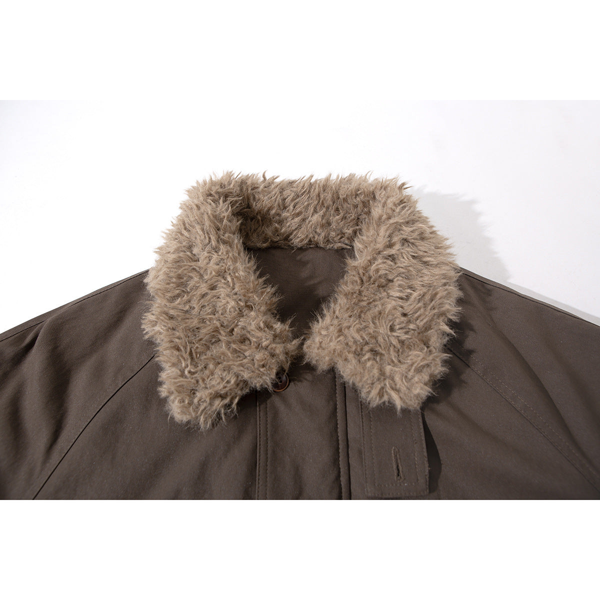 Close-up of a dark brown jacket with a large shaggy tan collar and button-front placket.