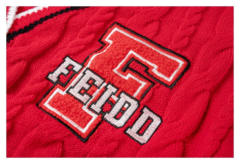 Close-up of a raised FEIDO patch embroidered on the red cardigan's cable-knit fabric.