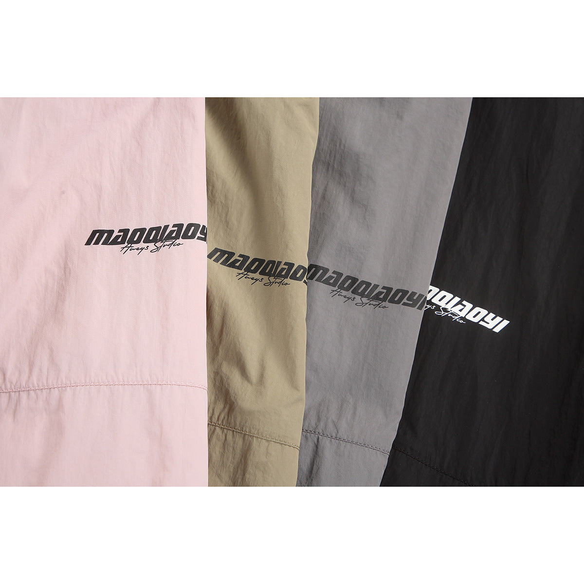 Close-up of pink, beige, gray, and black garment fabric with printed black or white logos and horizontal seams.