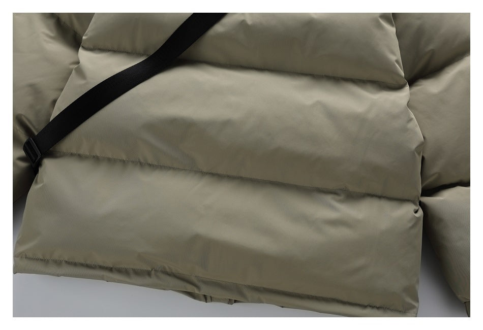 Close-up of the olive-khaki puffer jacket's lower back panels and a black diagonal strap.