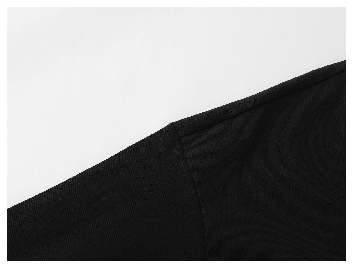 Close-up of the black shirt's shoulder seam against a white background.