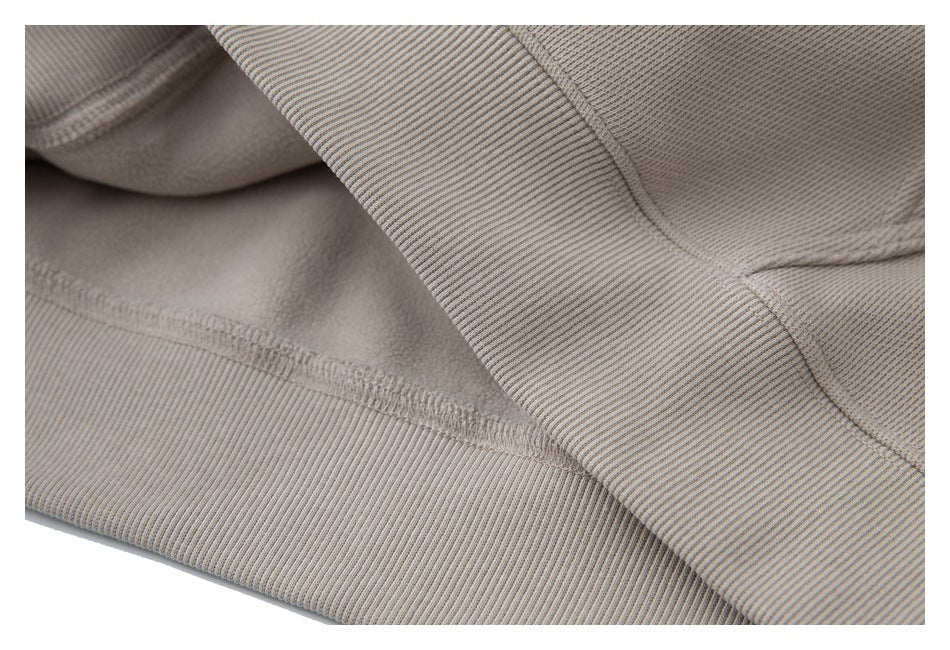 Close-up of a beige garment's ribbed edge and stitched seam.