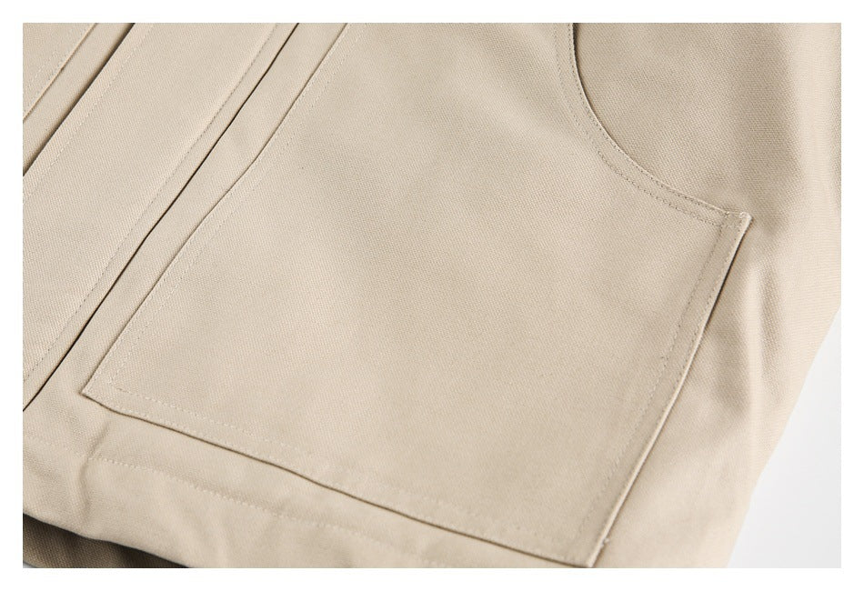 Close-up of a large square patch pocket and stitching on a beige garment.
