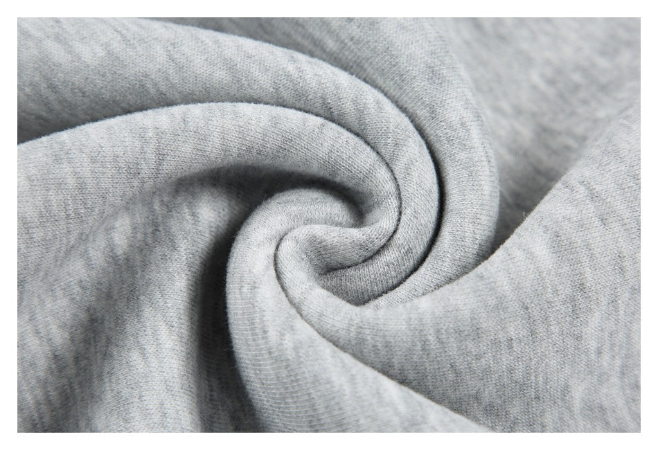 Close-up of heather gray garment fabric gathered into soft folds, showing its knit texture.