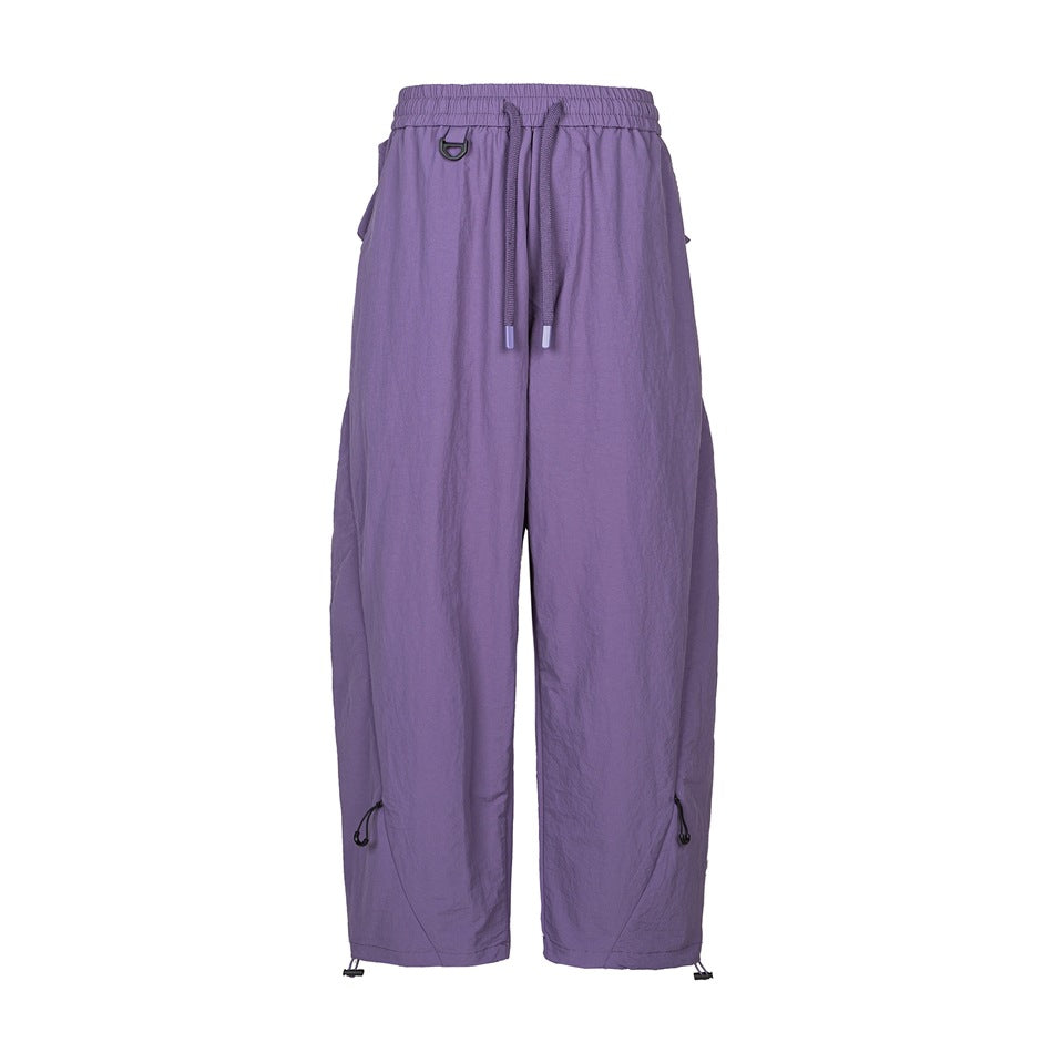 Purple wide-leg drawstring pants with D-ring, side flap pockets and toggle drawcord hems, front flat view