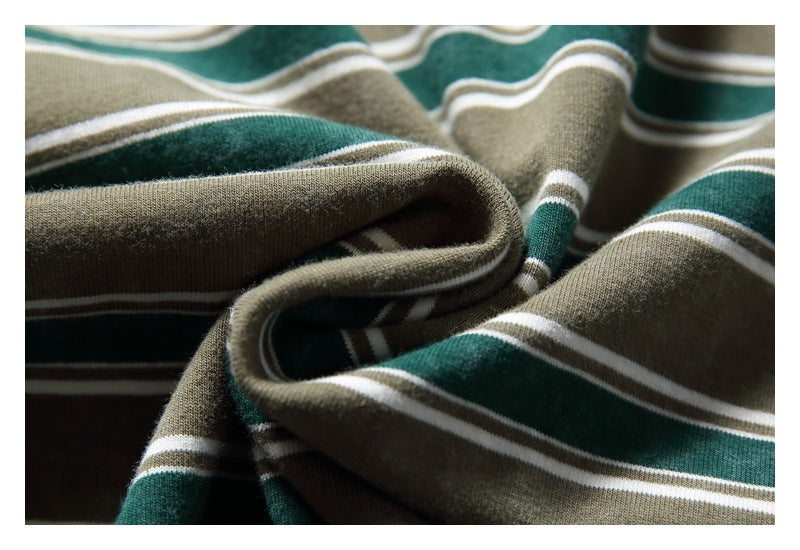 Macro view of folded olive-gray fabric with dark green and white stripes.