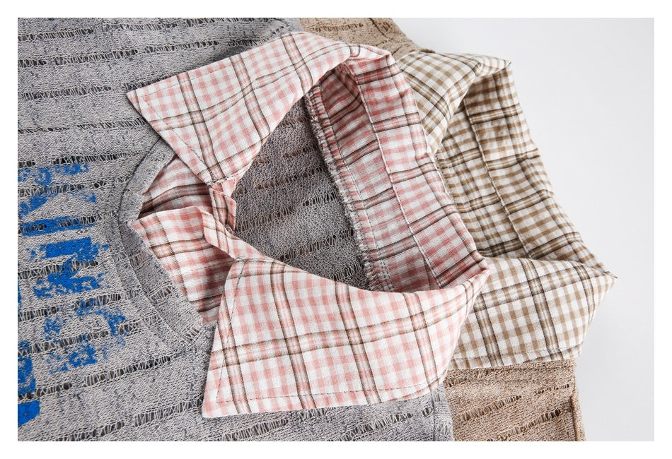 Close-up of layered gray and beige shirts showing contrasting pink and brown checked collars and fabric details.