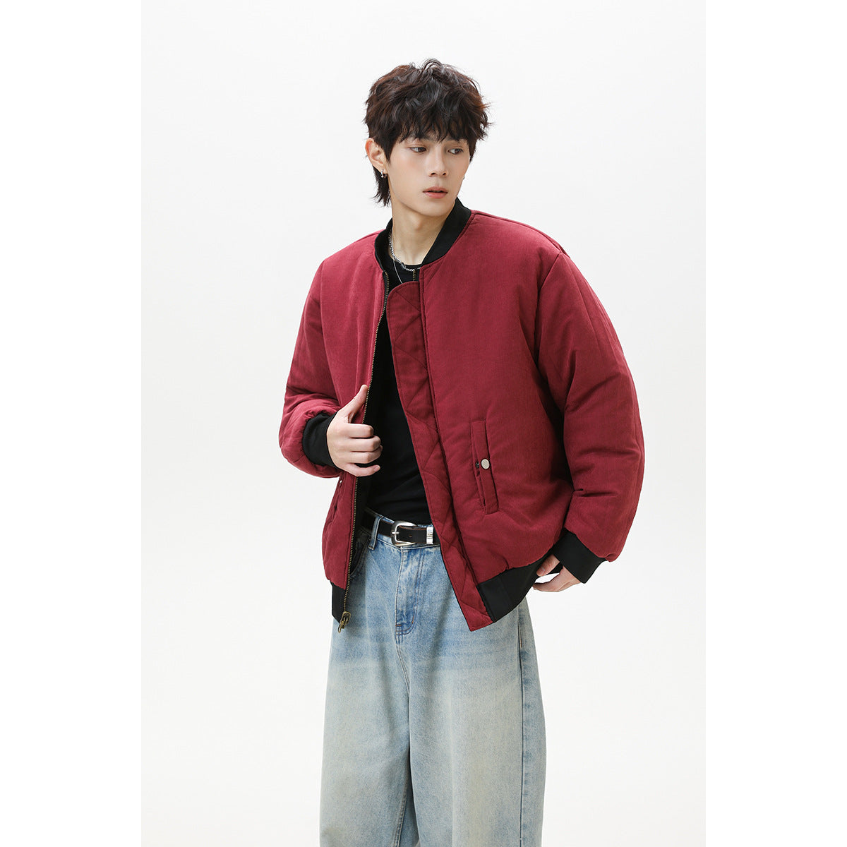 Model wears an open burgundy bomber jacket with black trim and snap pockets.