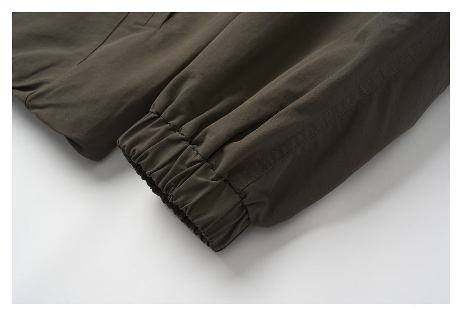 Close-up of a dark olive-brown sleeve ending in a gathered elastic cuff.