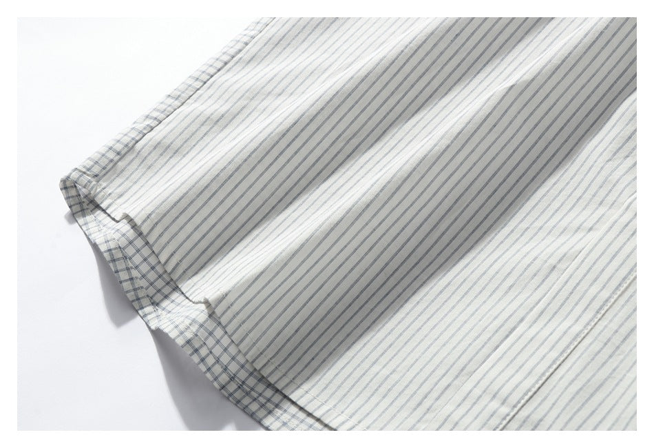 Close-up of a white shirt hem with fine blue-gray stripes and checked trim.