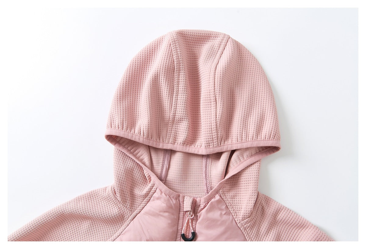 Close-up of a pink jacket's hood, textured panels, neckline, and front zipper pull.