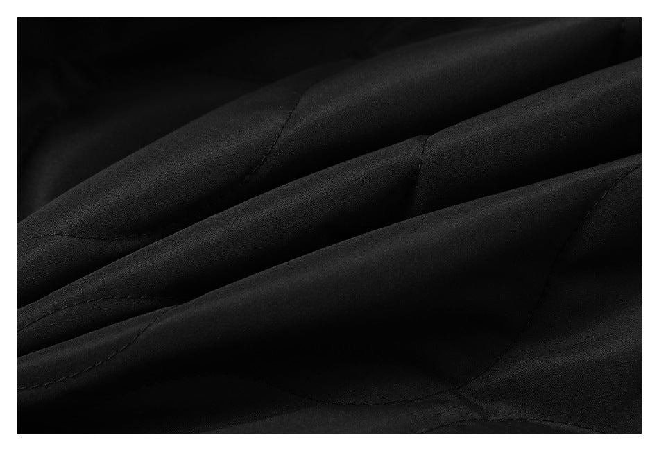 Close-up of black garment fabric with curved stitched seams and soft folds.