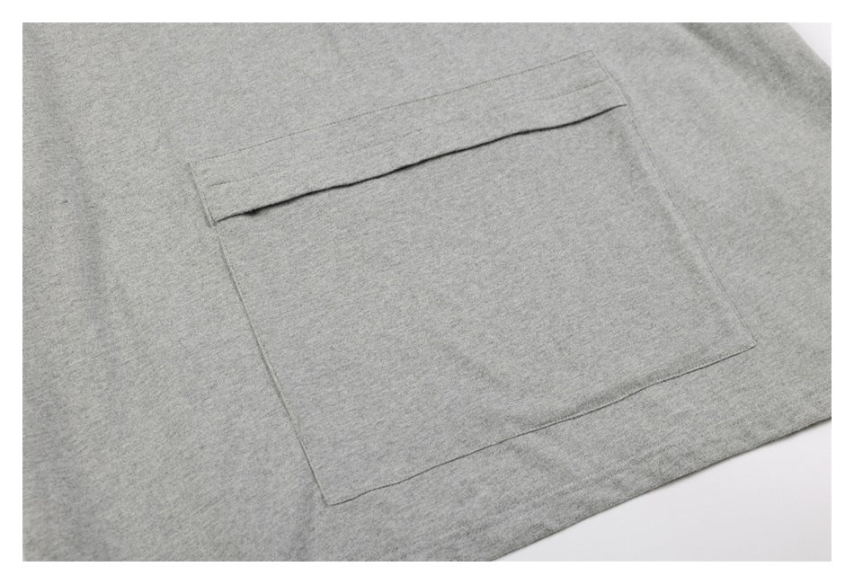 Close-up of a large patch pocket with a folded top edge on a heather gray shirt.