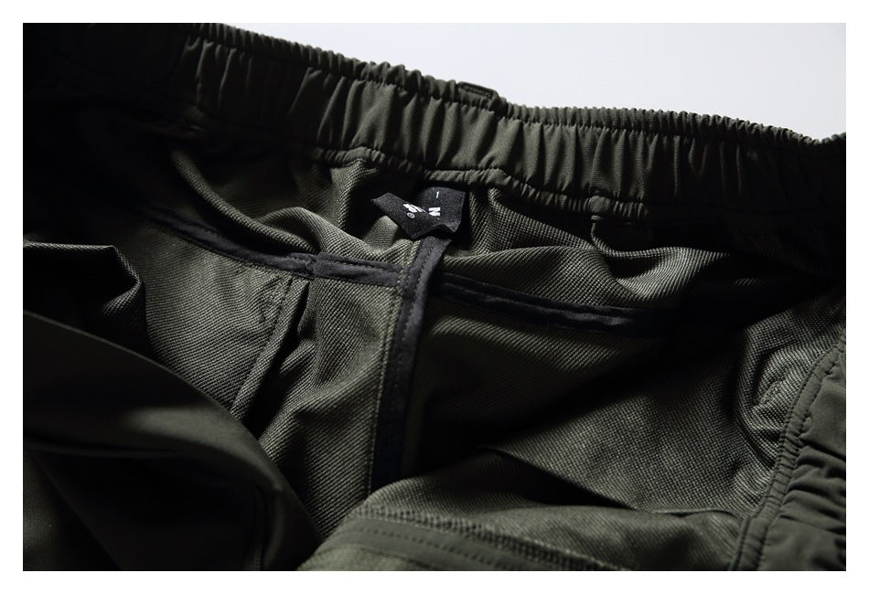 Interior close-up of dark olive pants showing the elastic waistband and inner seams.