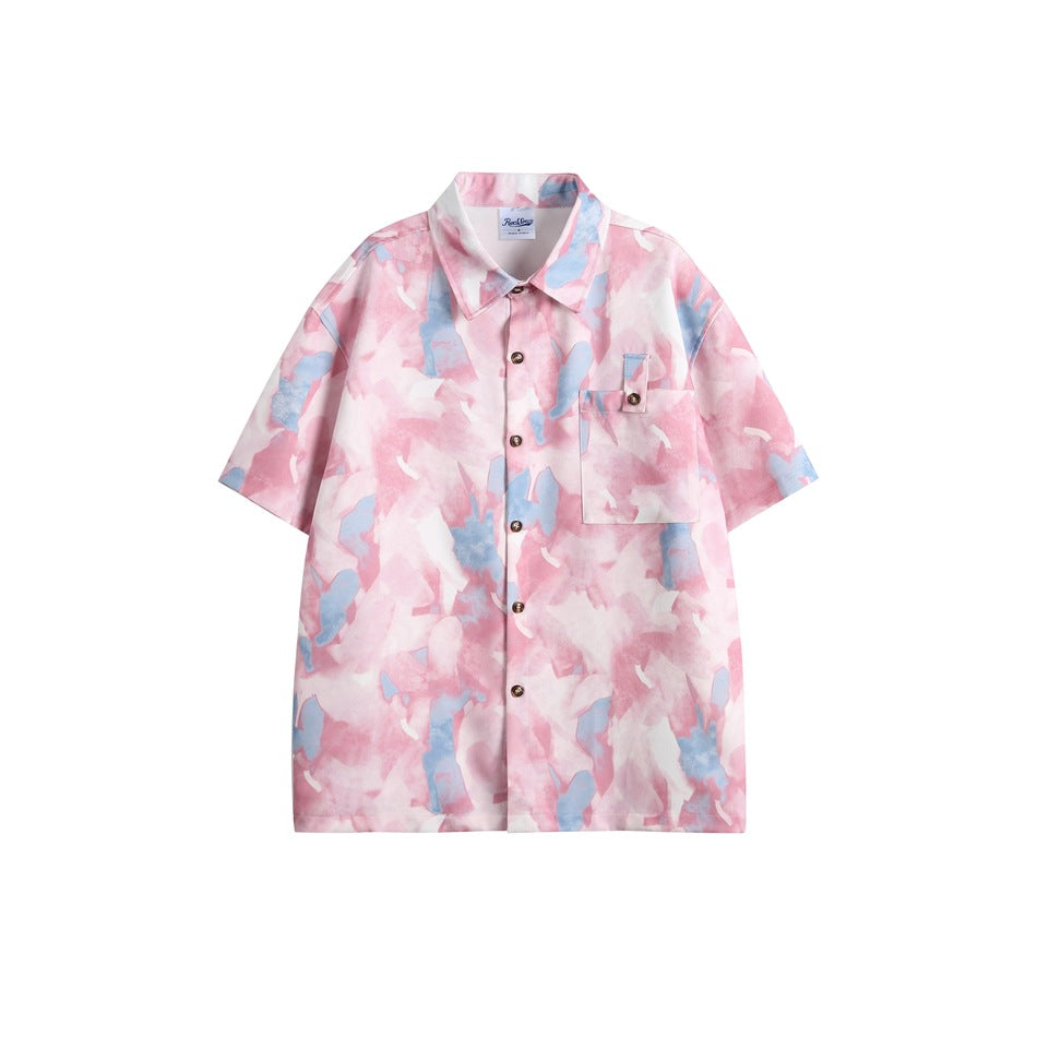 Front view of a pink and blue abstract-print short-sleeve button-up shirt with a collar, buttons, and chest pocket.