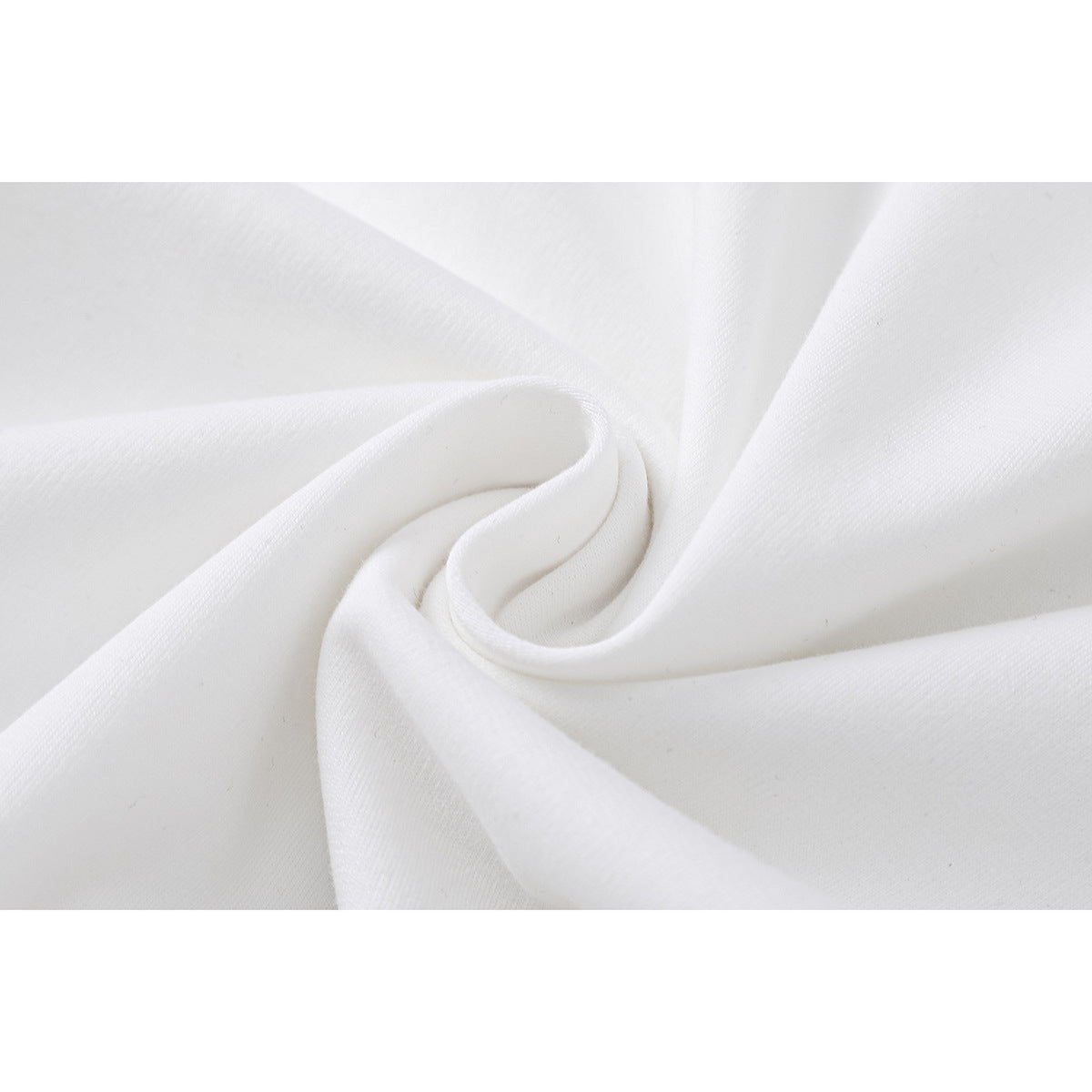 Close-up of white fabric gathered into soft folds, showing its surface texture.