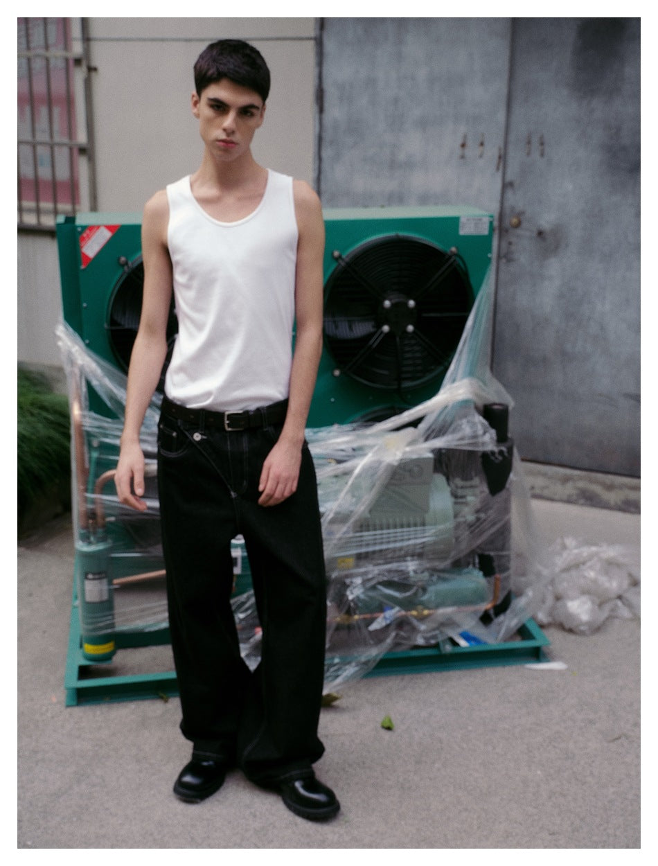 Front view of a model wearing a white tank top and black wide-leg jeans with a belt.