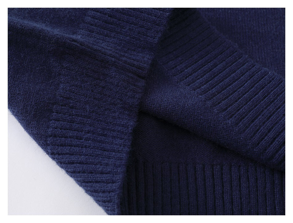 Close-up of a dark navy knit garment showing ribbed sections and a folded seam.