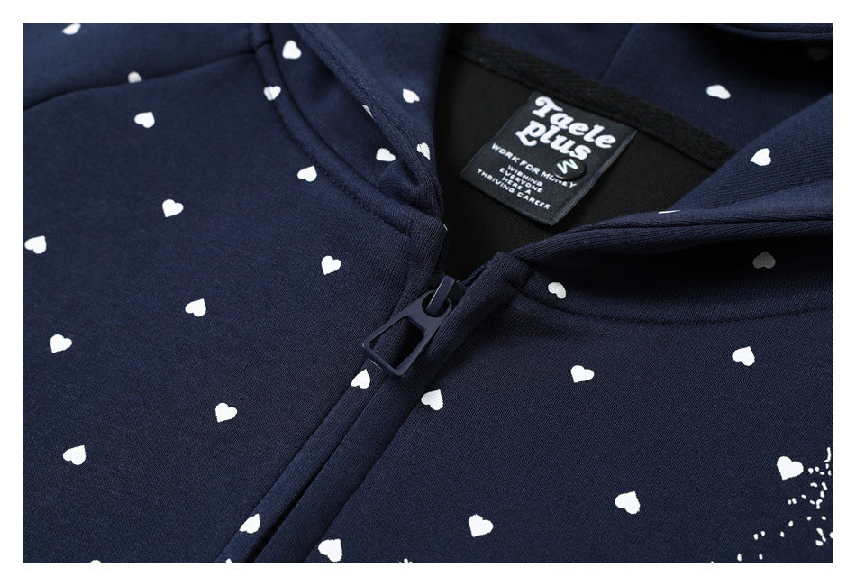 Close-up of a navy zip-up hoodie with small white heart prints and a visible neck label.
