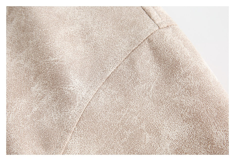 Close-up of a curved stitched seam on pale beige mottled fabric.