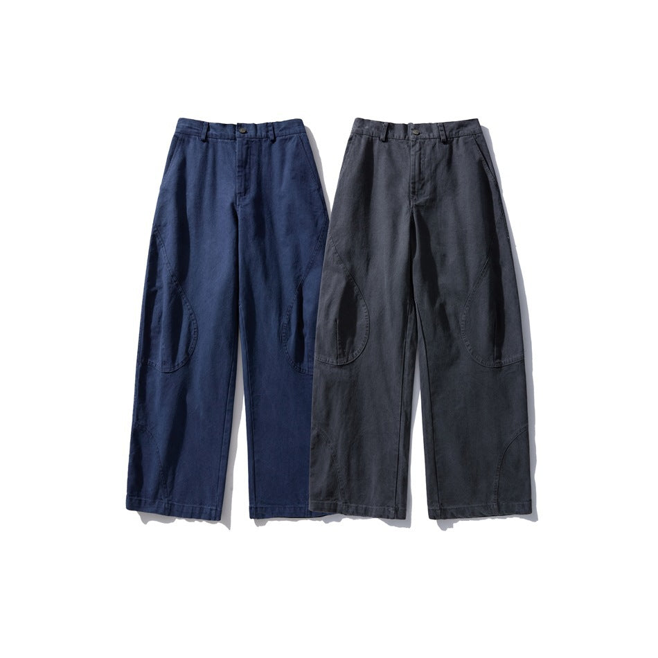 Two pairs of loose trousers shown from the front in navy blue and charcoal gray, with curved panel seams.