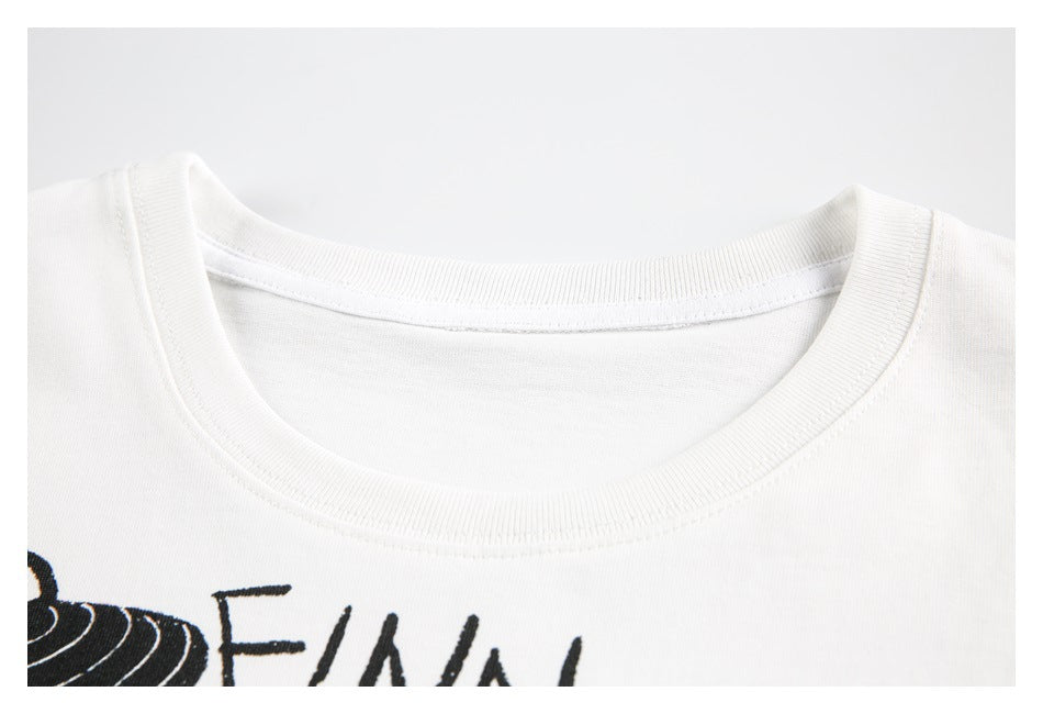 Close-up of the white T-shirt's ribbed crew neckline and a small portion of its black print.