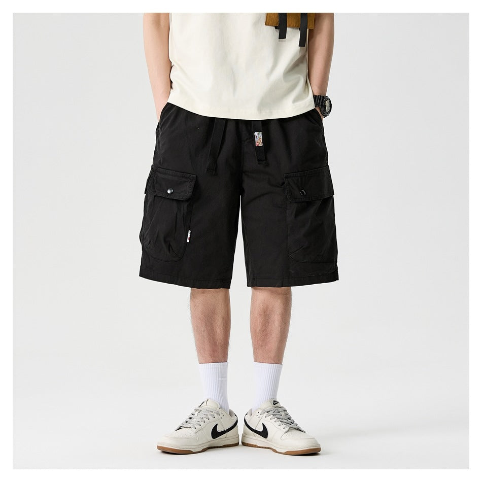 Front view of a model wearing black cargo shorts with a drawstring waist and two flap pockets.