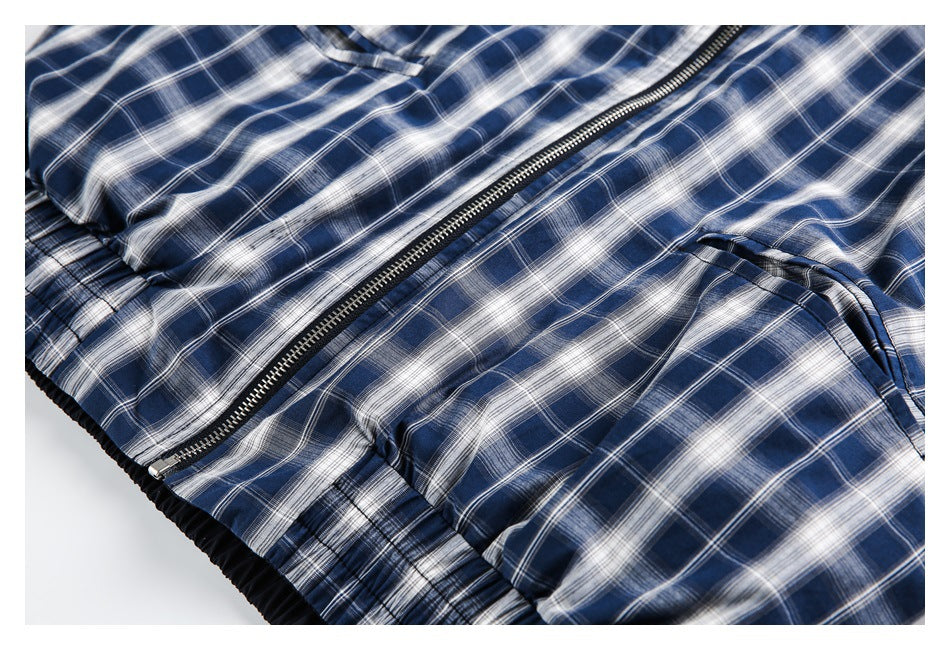Partial front view of a blue-and-white plaid jacket with a dark zipper and gathered waistband.