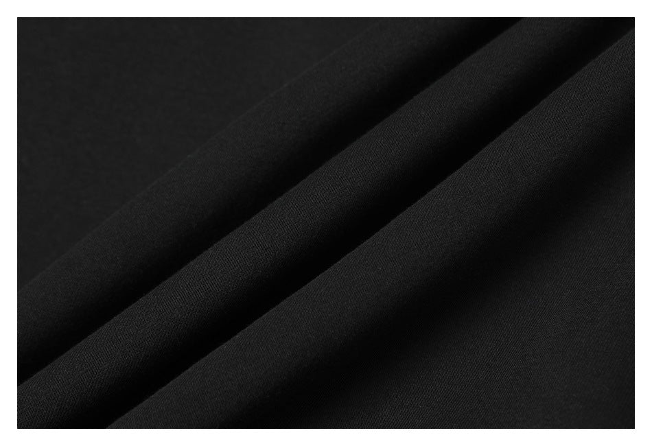 Close-up of smooth black fabric arranged in diagonal folds.