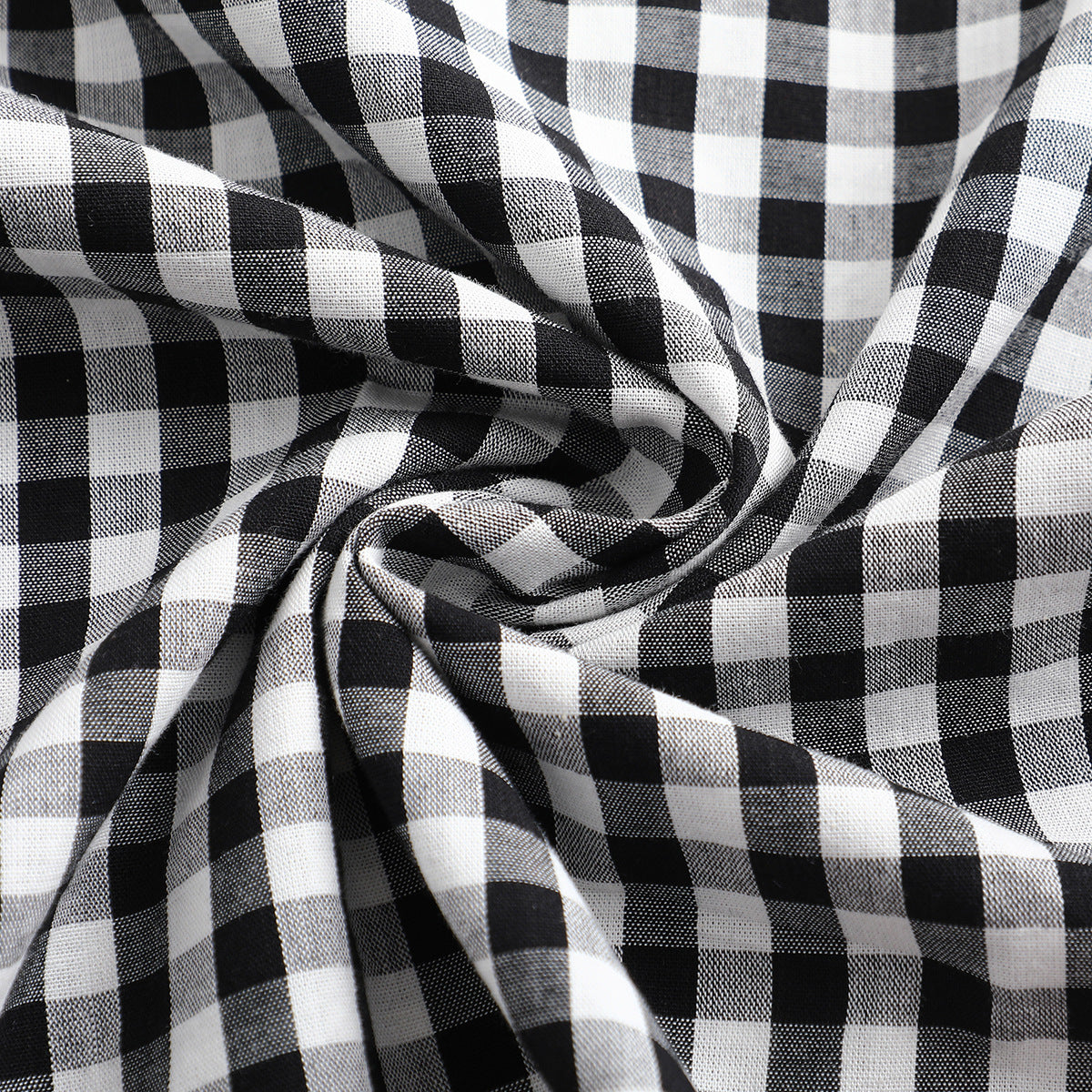Close-up of black-and-white checked shirt fabric gathered into folds.