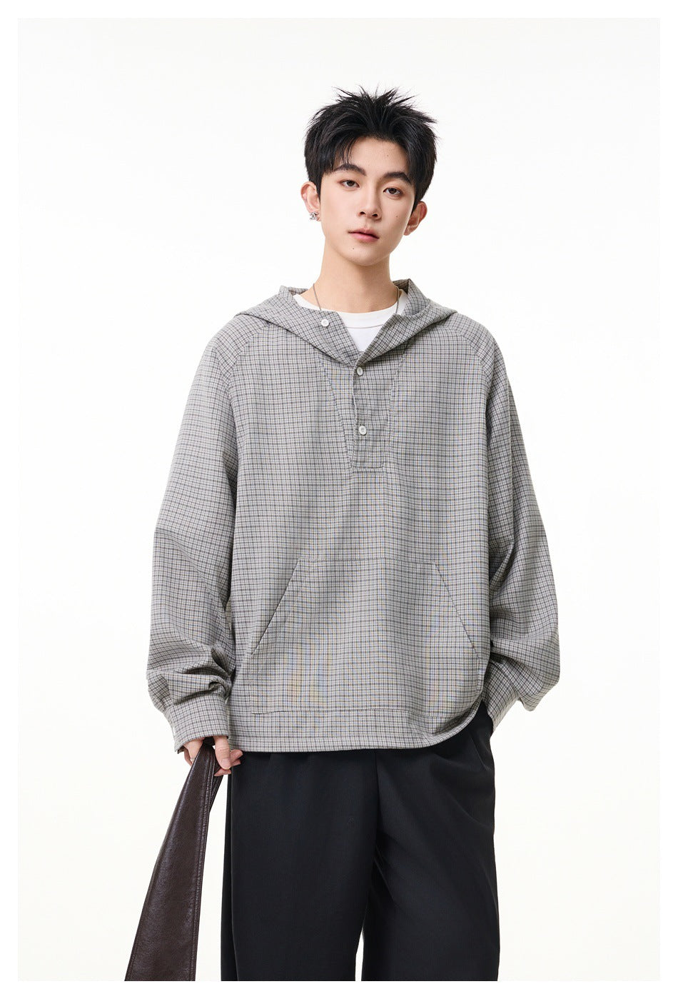 Front view of a model in a gray micro-check hooded pullover with a button placket and large kangaroo pocket.