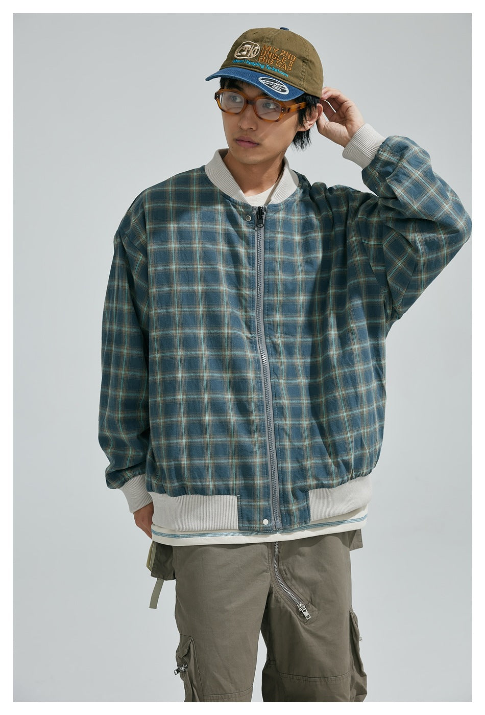 Model wearing a blue plaid zip-front jacket with white ribbed collar, cuffs and hem, shown from the front.