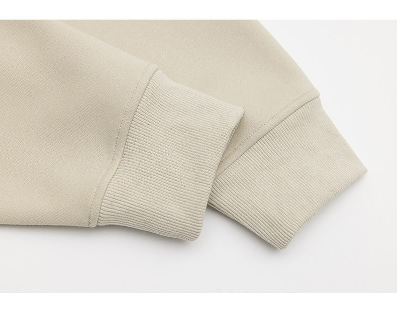 Close-up of the beige sweatshirt’s ribbed sleeve cuffs and seams.