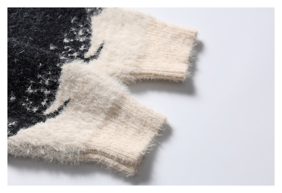 Close-up of two ivory ribbed sleeve cuffs against the black-and-ivory pattern of a fuzzy knit sweater.