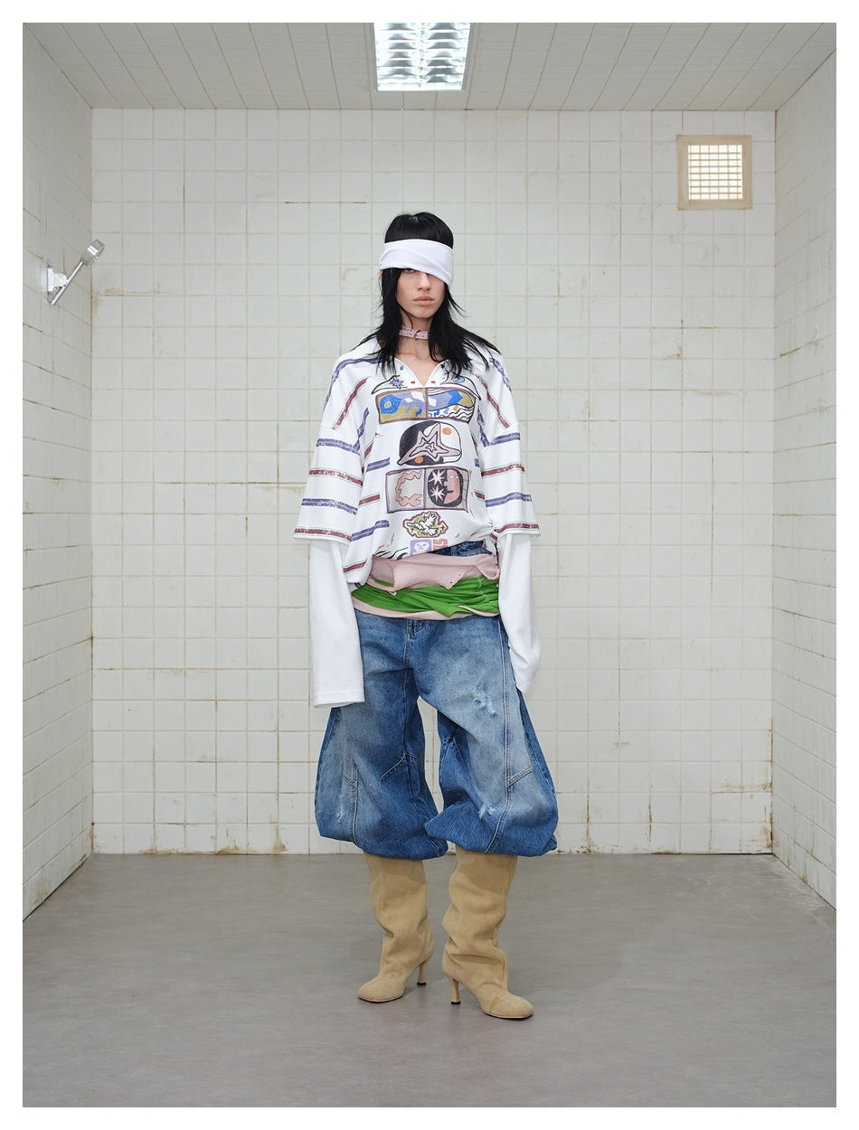Model wearing the white striped graphic polo top with layered sleeves, front view, styled with wide-leg jeans and boots