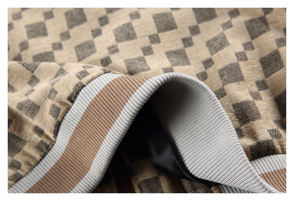 Close-up of a folded ribbed hem with taupe and light gray stripes against beige geometric-patterned fabric.