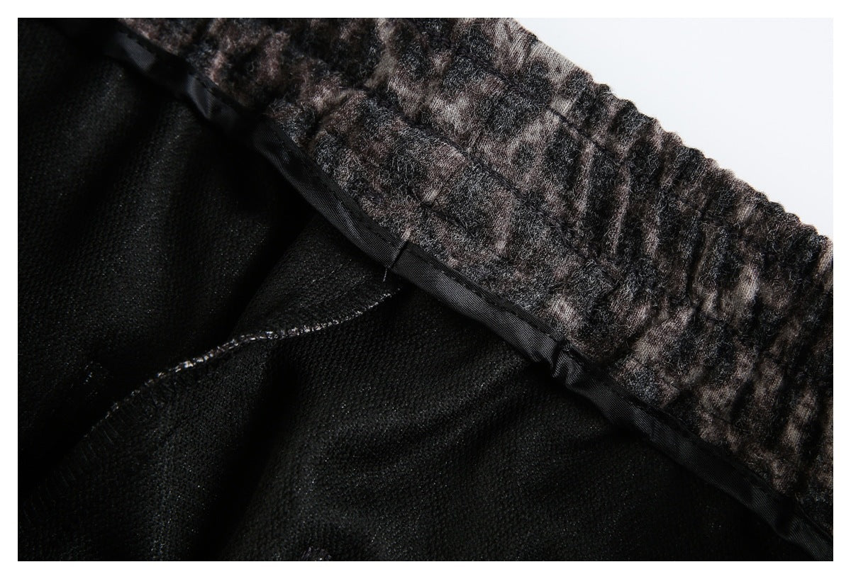 Inside close-up of leopard-print fabric with a gathered elastic edge, black backing, and visible seams.