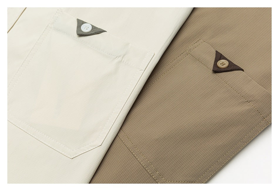 Close-up of cream and taupe garments showing stitched pockets with triangular button tabs.
